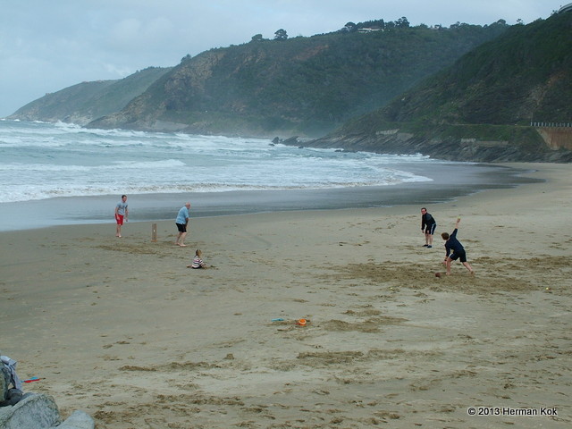 Family playing cricket on the beach